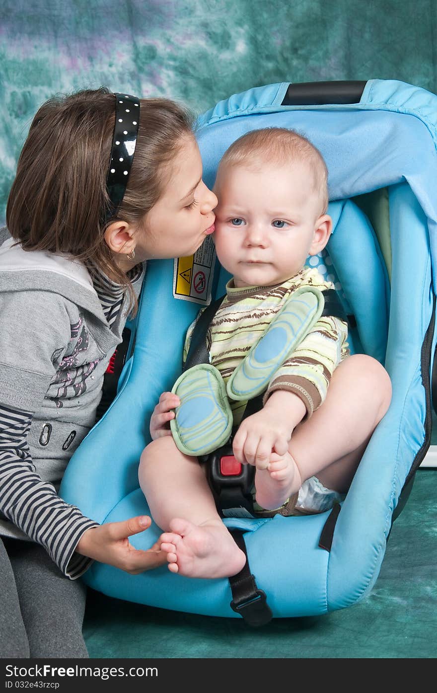 To the child seven months, he sits in a children's automobile armchair, and nearby elder sister. To the child seven months, he sits in a children's automobile armchair, and nearby elder sister.