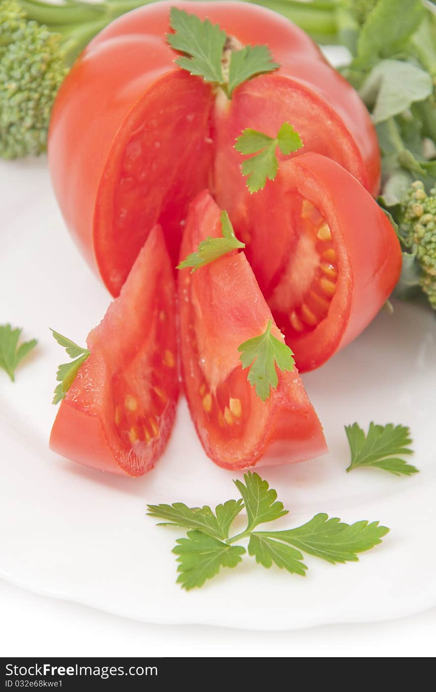 Tomatoes and parsley, served on white plate. Tomatoes and parsley, served on white plate