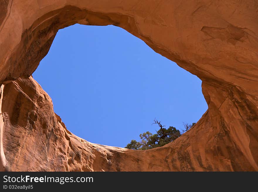 Bowtie Arch, a pothole arch formed when a pothole broke through from the top of the cliff. Corona Arch Trail, Moab, just outside Arches National Park. Bowtie Arch, a pothole arch formed when a pothole broke through from the top of the cliff. Corona Arch Trail, Moab, just outside Arches National Park.