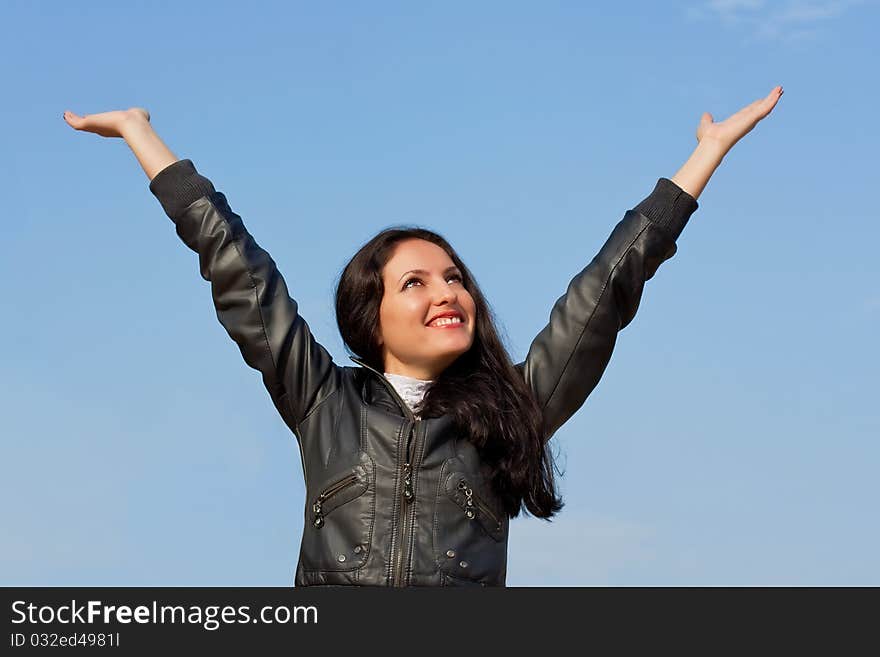 A young woman stretches her hand towards the sky. A young woman stretches her hand towards the sky