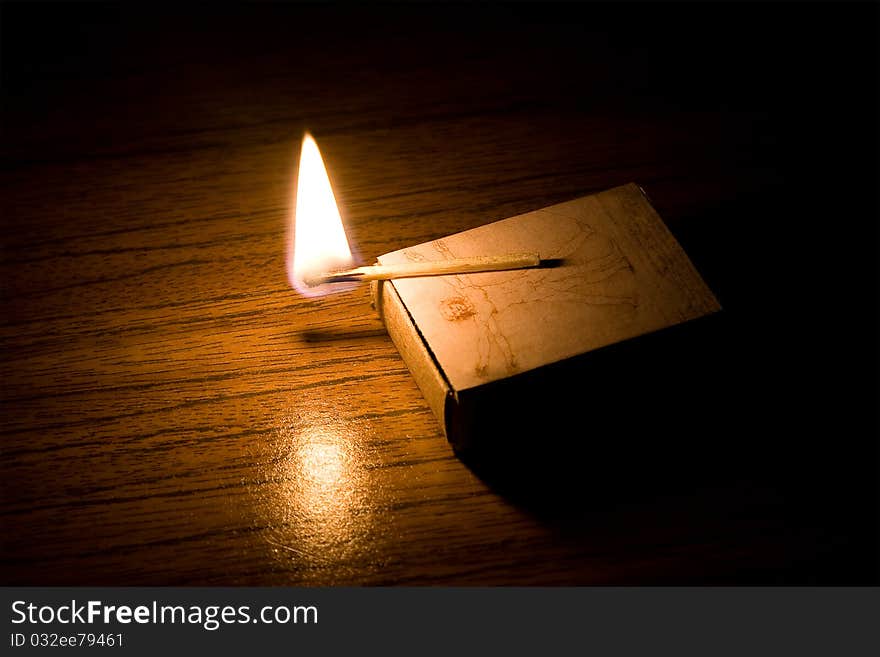 A conflagrant match lights up a table. A conflagrant match lights up a table