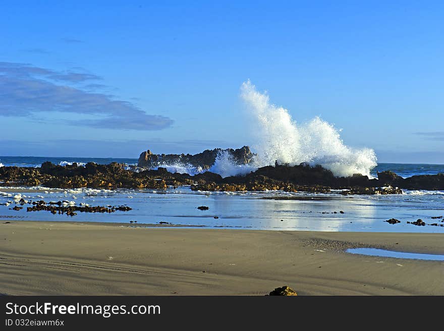 A huge wave crashes on the rocks early in the mornng. A huge wave crashes on the rocks early in the mornng