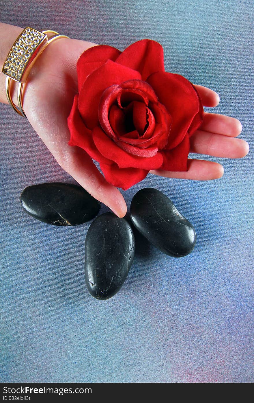 Spa concept with hand of a woman holding red rose and spa stones. Spa concept with hand of a woman holding red rose and spa stones.