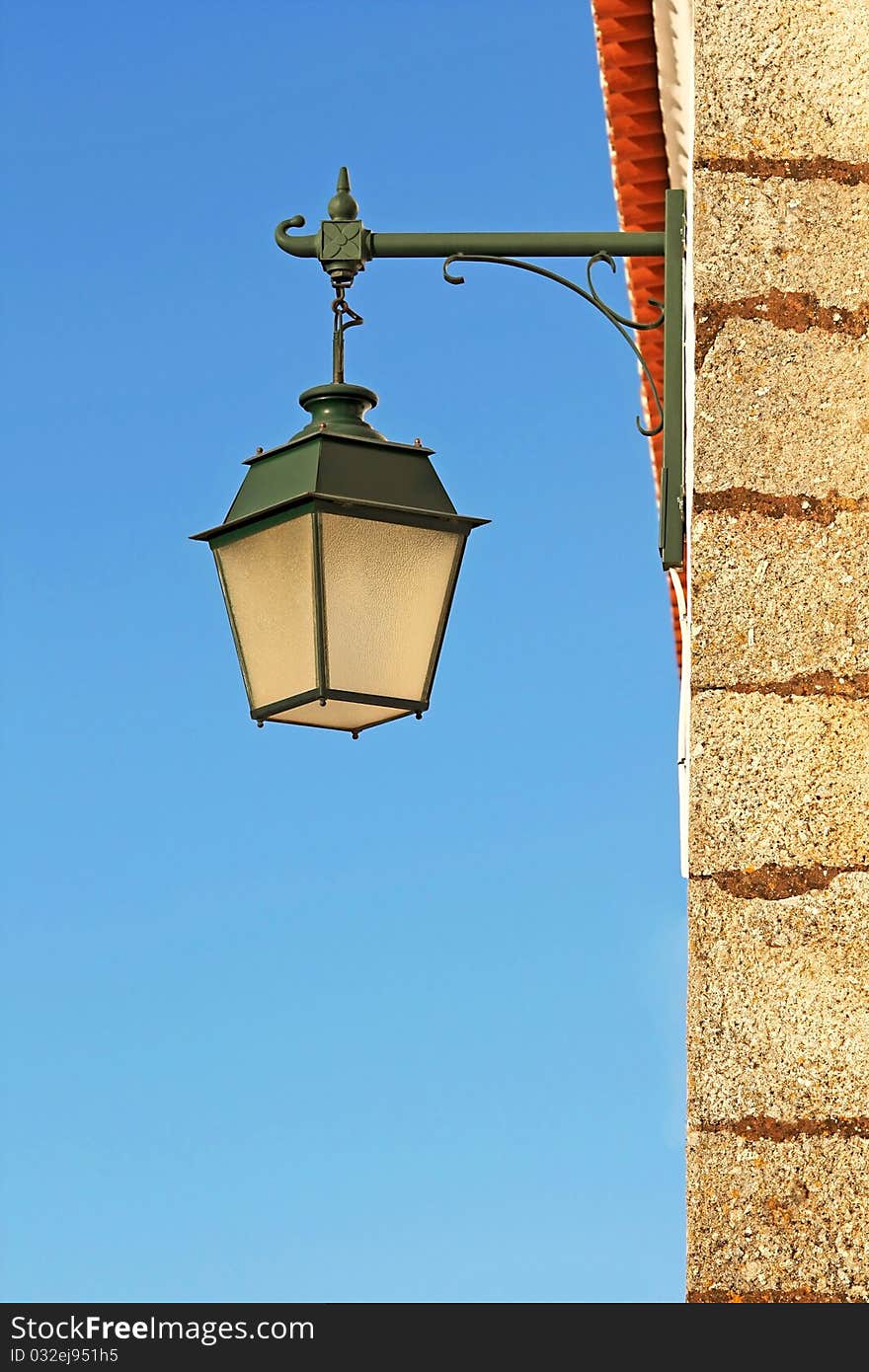 Ancient wall street green lamp with blue sky as background. Ancient wall street green lamp with blue sky as background