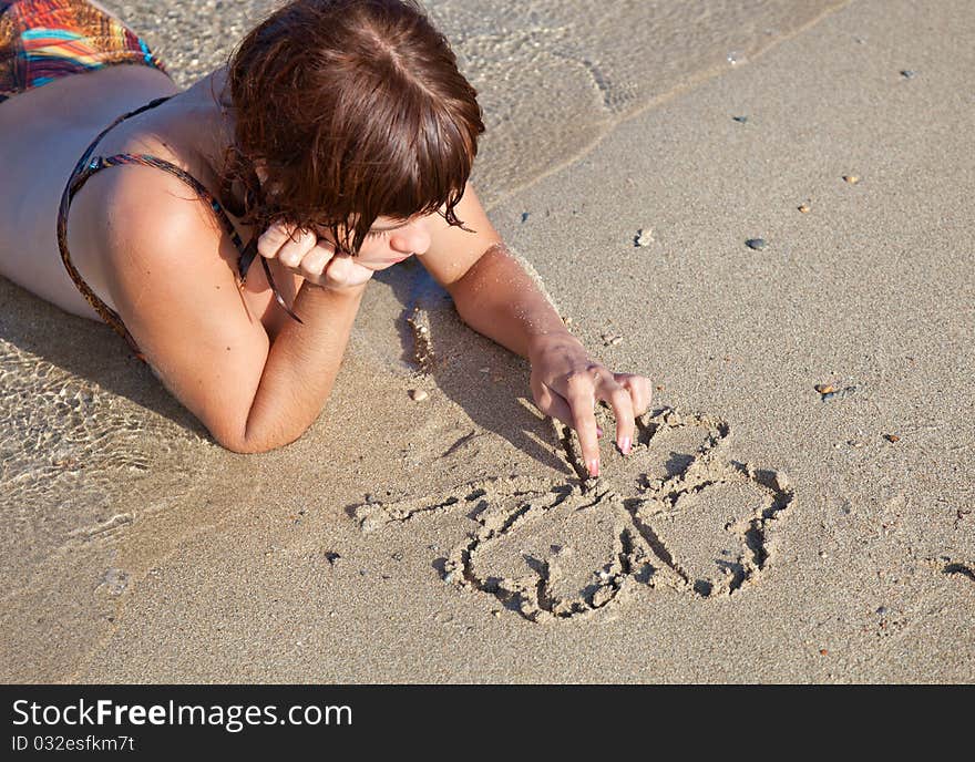 A Girl Is Painting A Clover On A Sand