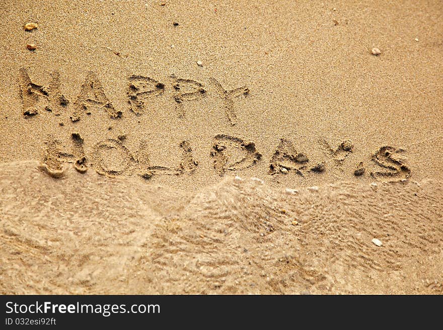 Inscription happy holidays on a sand. Inscription happy holidays on a sand