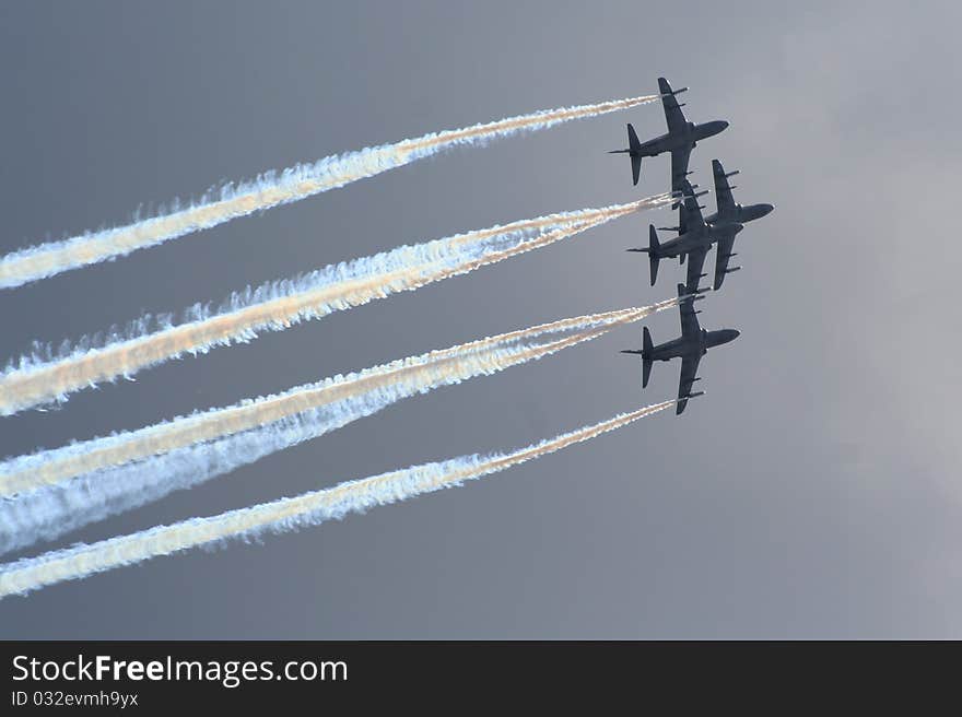 Aerobatic jet planes performing maneuvers during an air show.