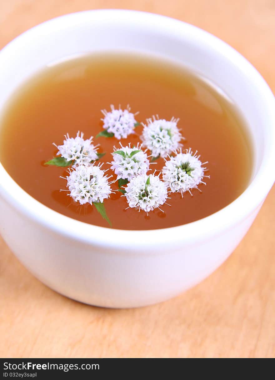 White bowl of green tea with mint twigs