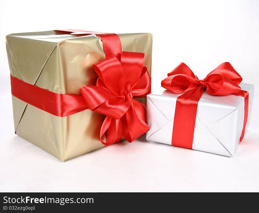 Gifts in silver and gold wrapping with red bow