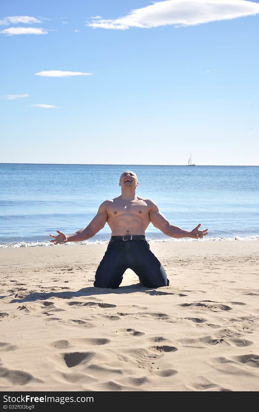 Muscular man kneel on beach and screaming. Muscular man kneel on beach and screaming