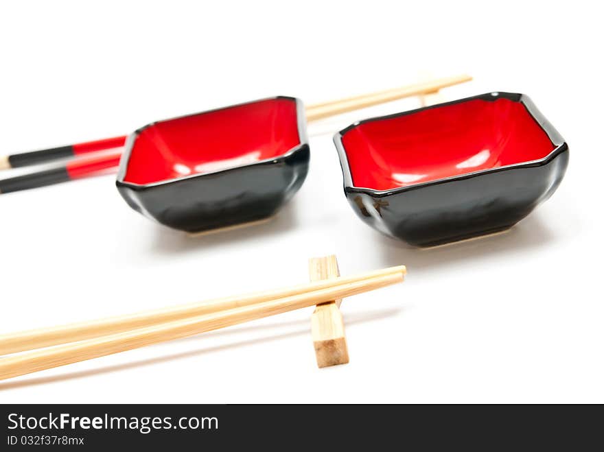 Black and red sushi set (chopsticks and plate) isolated on white background. Black and red sushi set (chopsticks and plate) isolated on white background