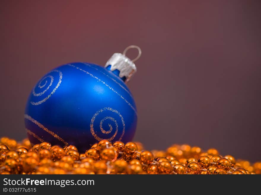 Christmas decoration with goden beaded garland and blue globe