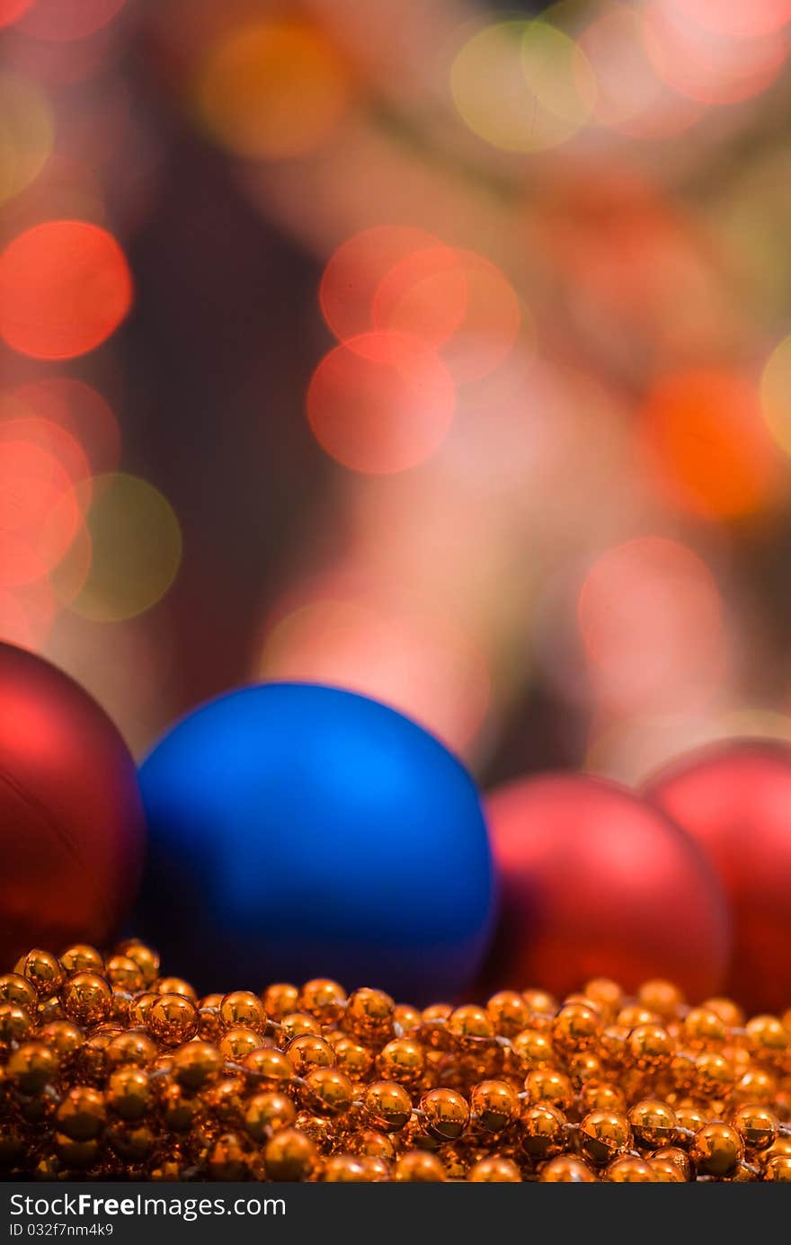 Colored decoration for Christmas with red and blue gobes and golden beaded garland