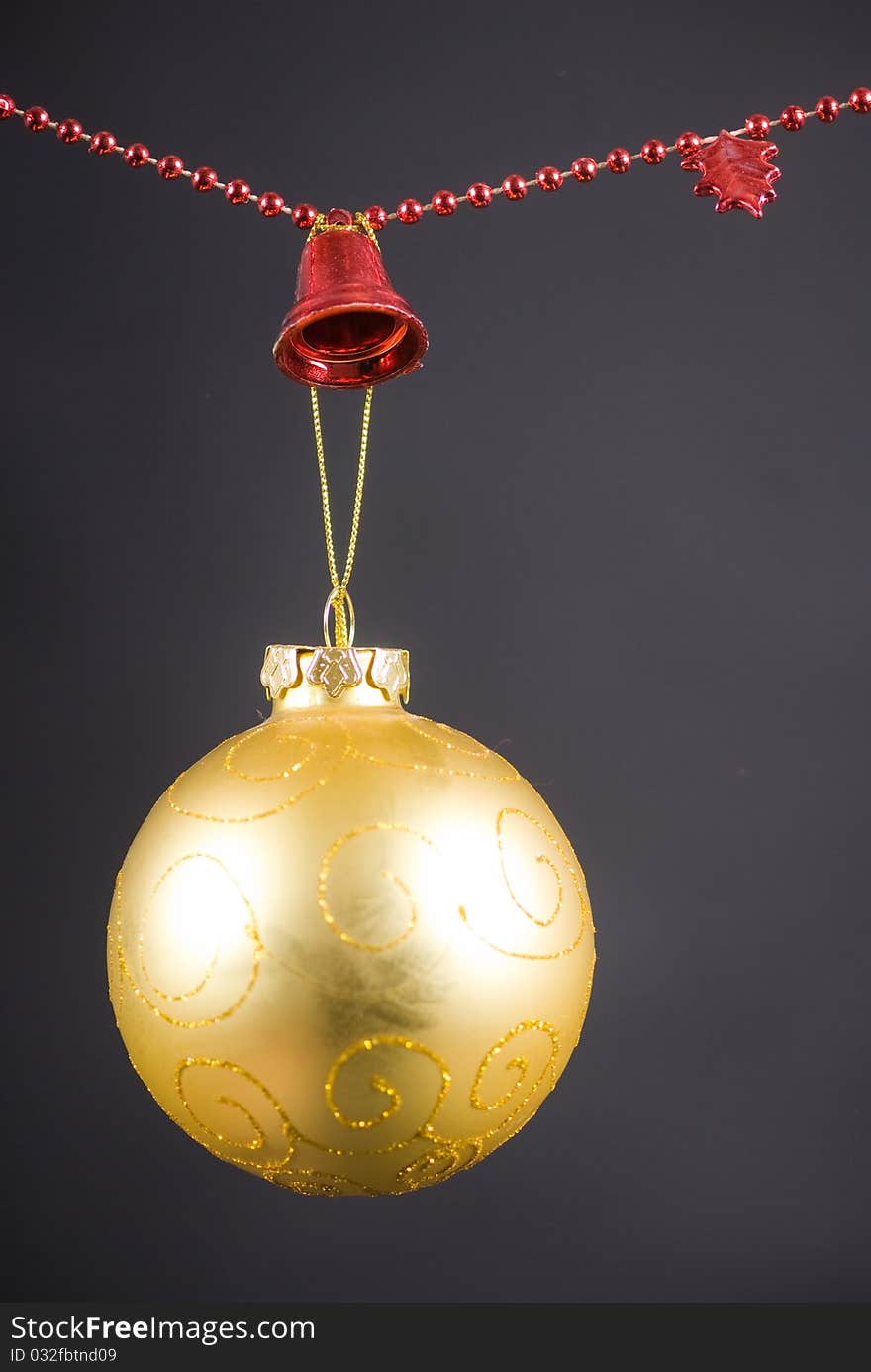 Christmas decoration with golden globe and red beaded garland