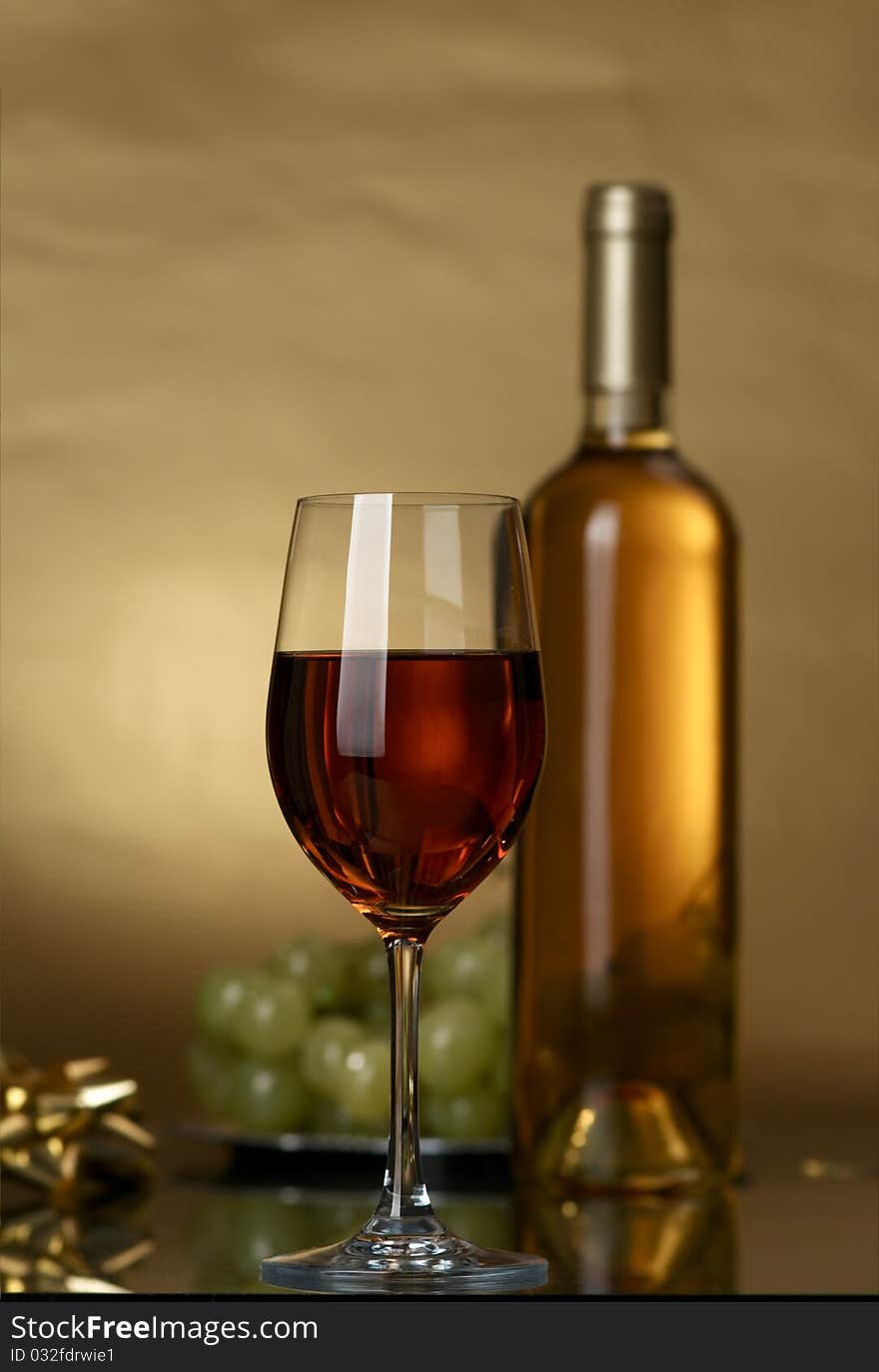 Bottle of white wine and white grapes on a yellow background