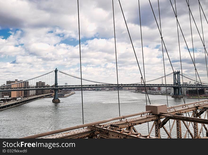 New York City Brooklyn Bridge in Manhattan closeup with skyscrapers and city skyline over Hudson River.