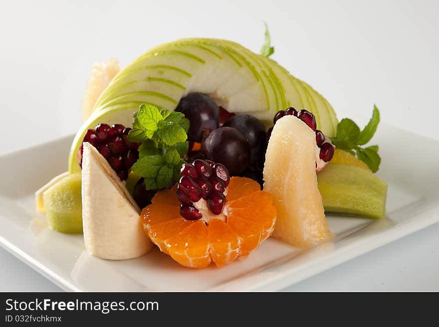 Plate full of fresh fruits isolated on white