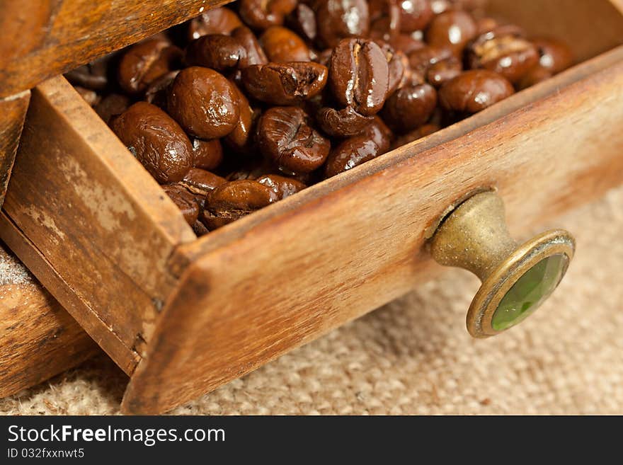 Fragrant fried coffee beans on the wooden coffee grinder