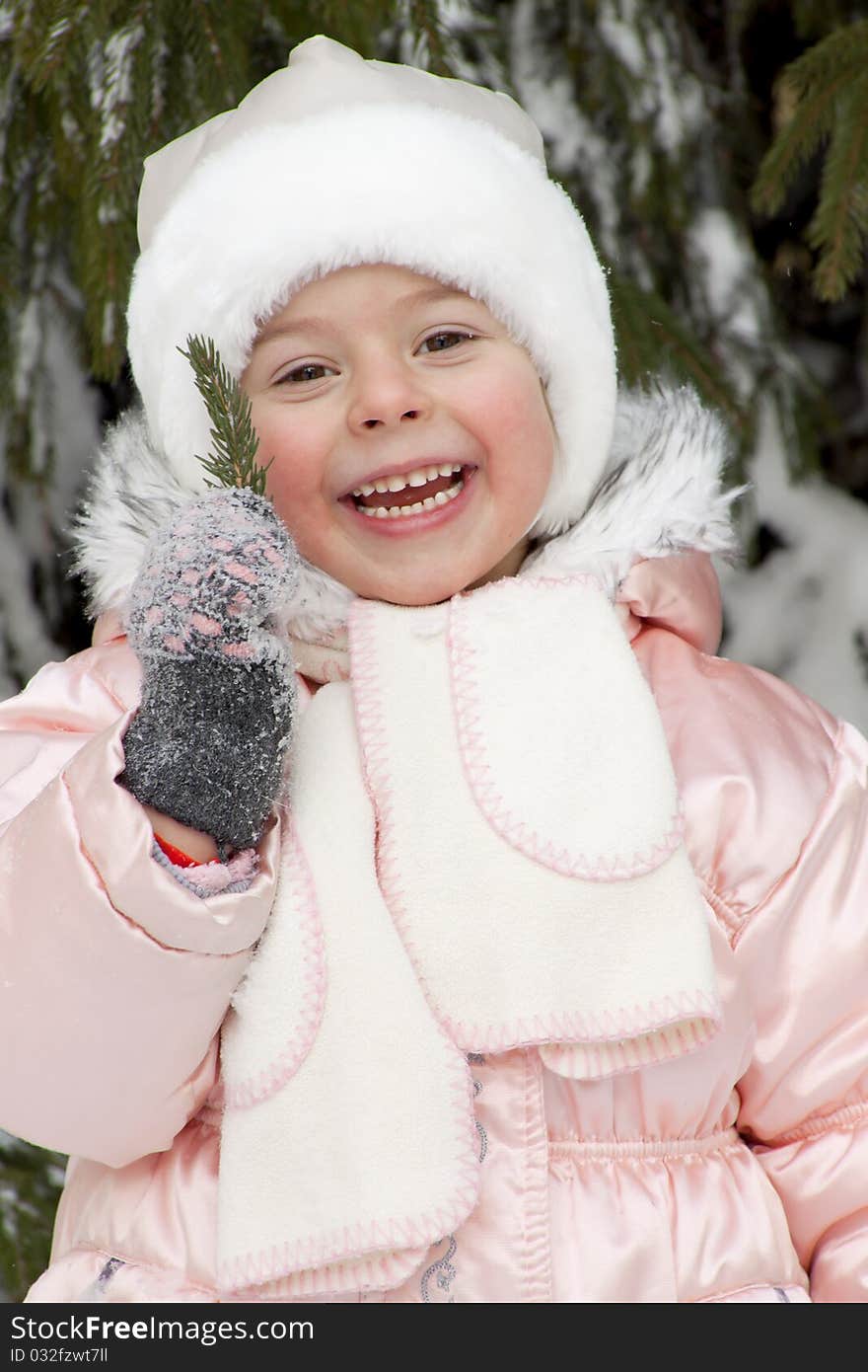 Warmly dressed joyful child costs and holds in hands a branch from a fur-tree. Warmly dressed joyful child costs and holds in hands a branch from a fur-tree