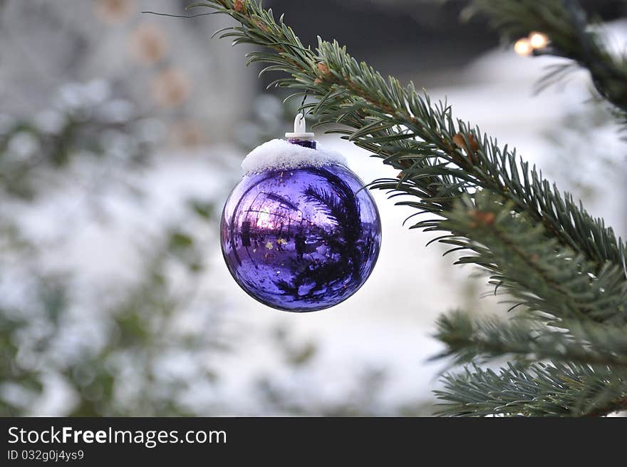 Christmas bauble on a snow encrusted tree