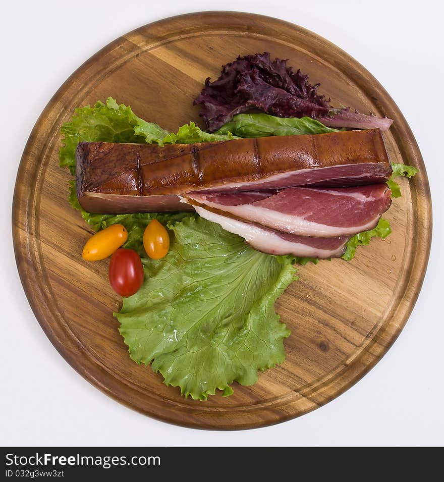 Breakfast close-up. Slices of bacon on the wooden plate with knife