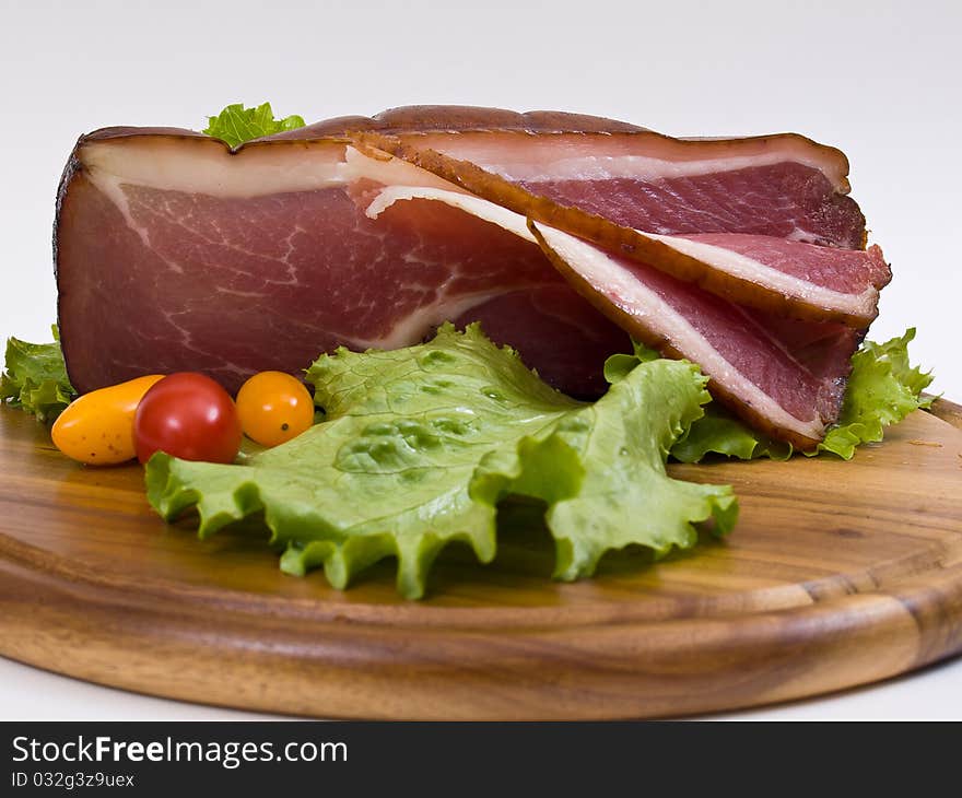 Breakfast close-up. Slices of bacon on the wooden plate with knife