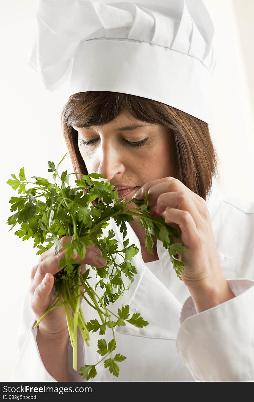 Female Chef Smelling Parsley, white background