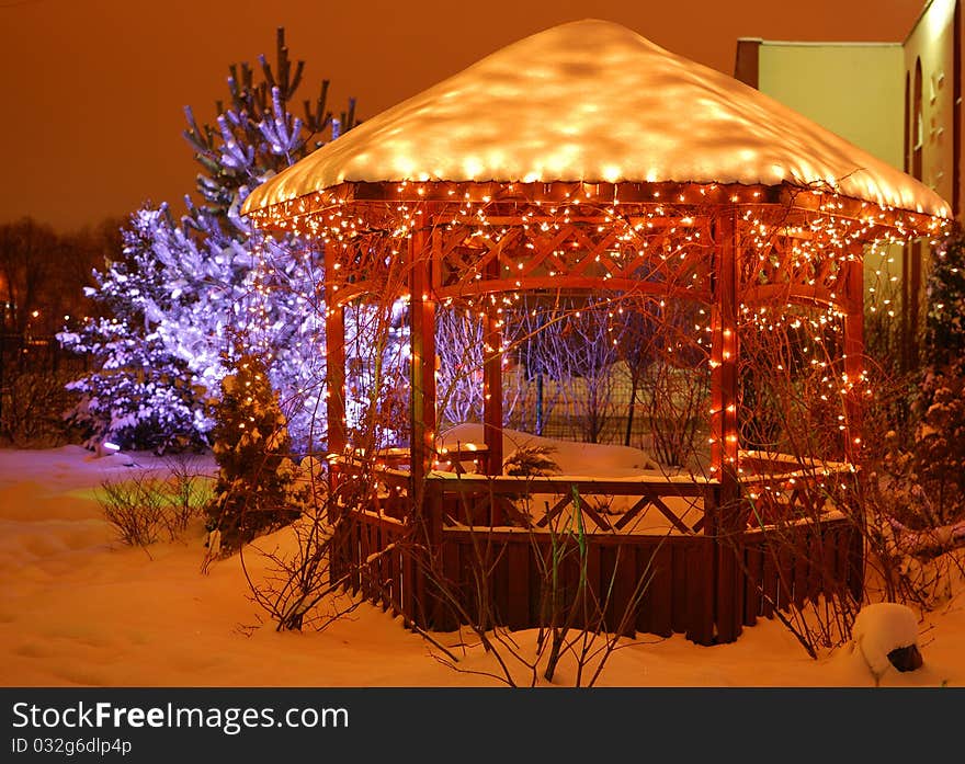 Garden under snow adorned with Christmas garlands. Garden under snow adorned with Christmas garlands