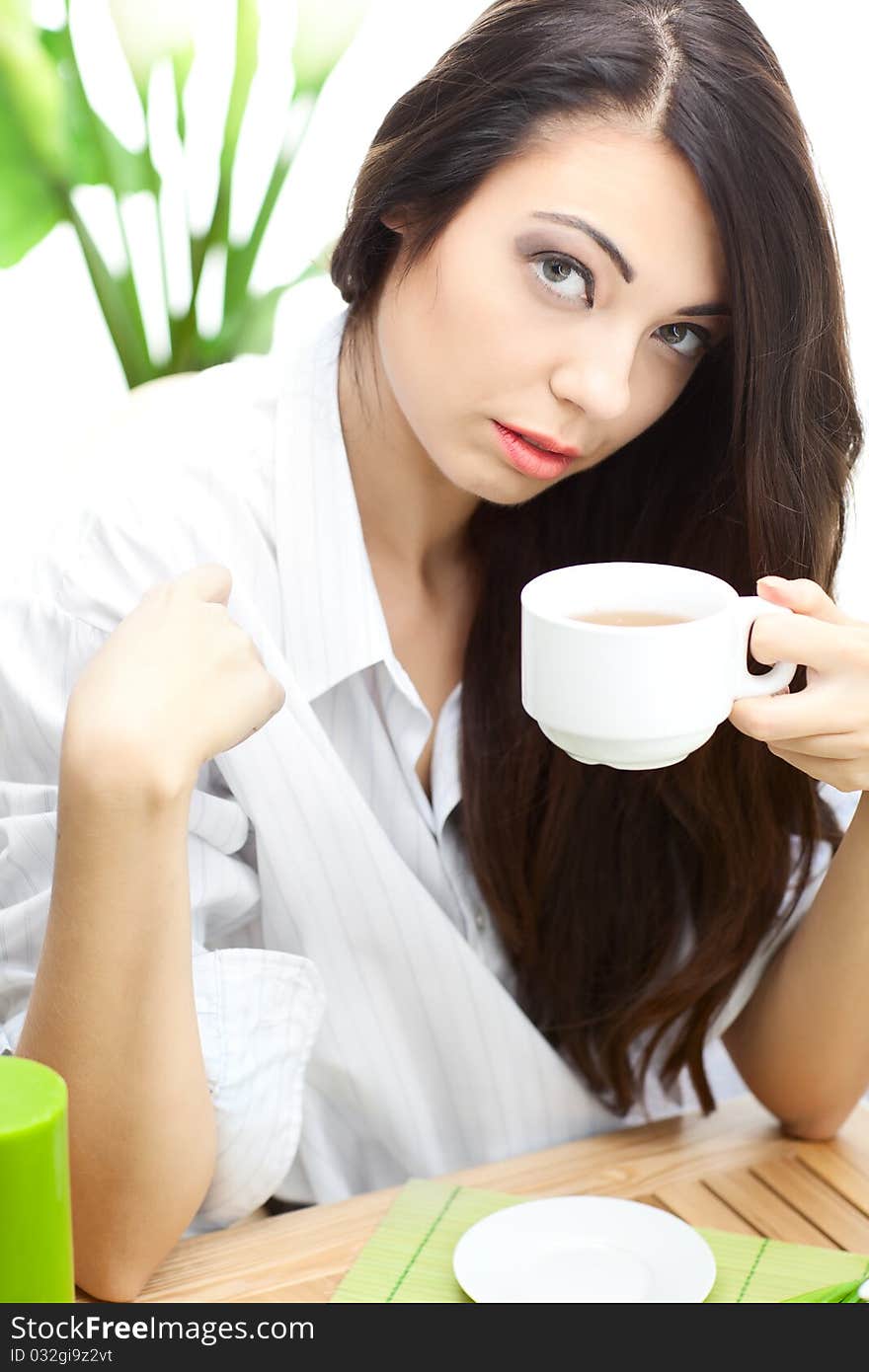 Woman dirinking tea smiling and looking at camera wearing formal clothes. Woman dirinking tea smiling and looking at camera wearing formal clothes