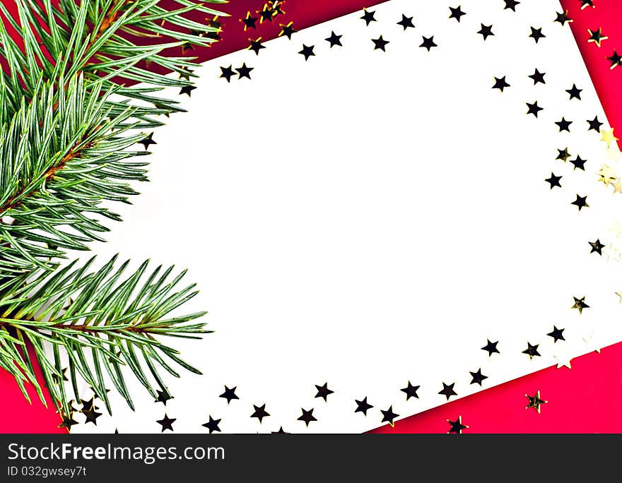 On a red background white greeting card with spruce twigs and golden stars. On a red background white greeting card with spruce twigs and golden stars.