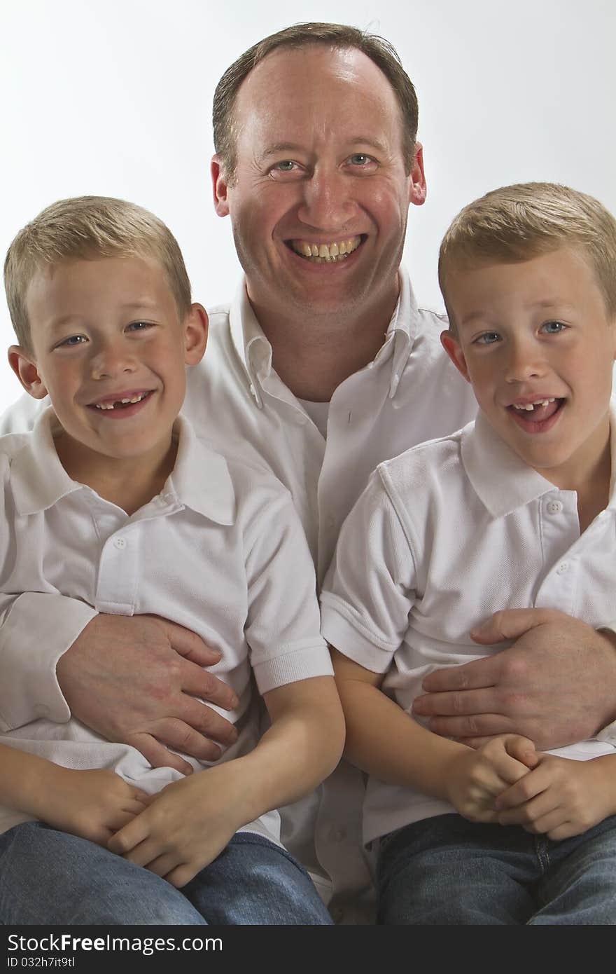 Happy Father holding his 6 years old identical twins. Happy Father holding his 6 years old identical twins