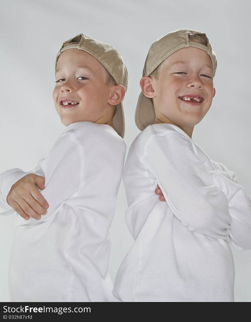 6 years old identical twins wearina a baseball hat