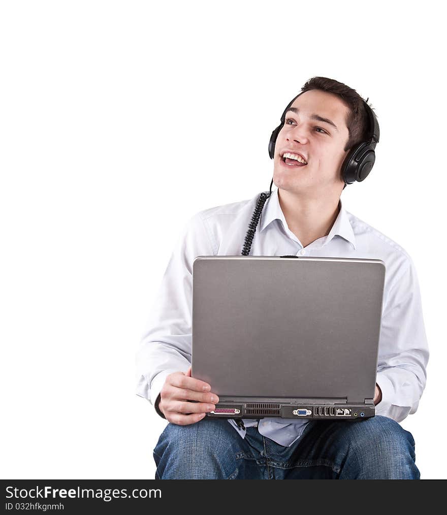 Young man sitting relaxing and listening to music from his laptop. Young man sitting relaxing and listening to music from his laptop.