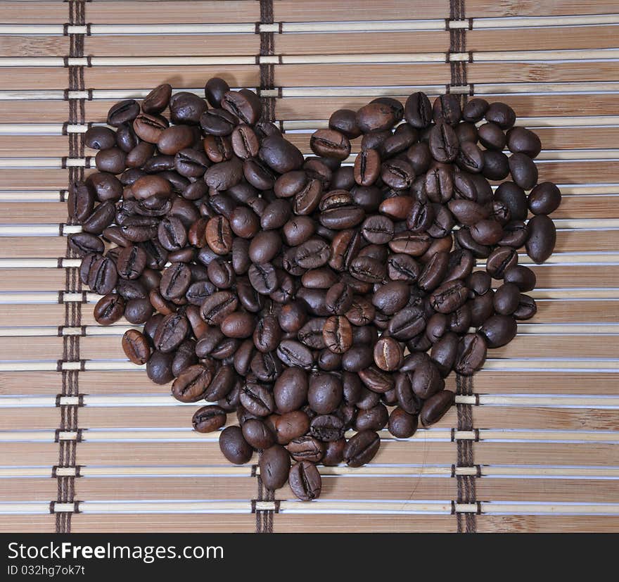 Picture of grains of lying black coffee as a heart. Picture of grains of lying black coffee as a heart