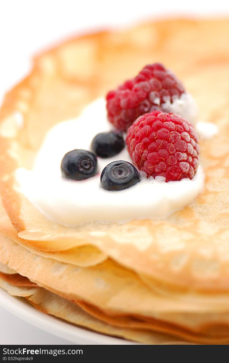 Pancakes topped with  raspberries, bilberries and