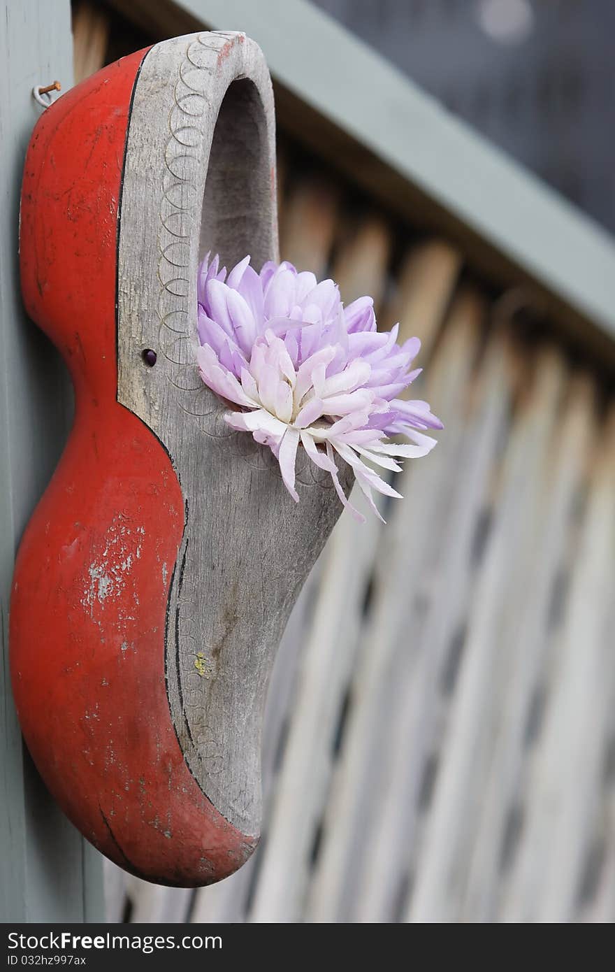 A weathered Dutch clog and cloth flowers. A weathered Dutch clog and cloth flowers