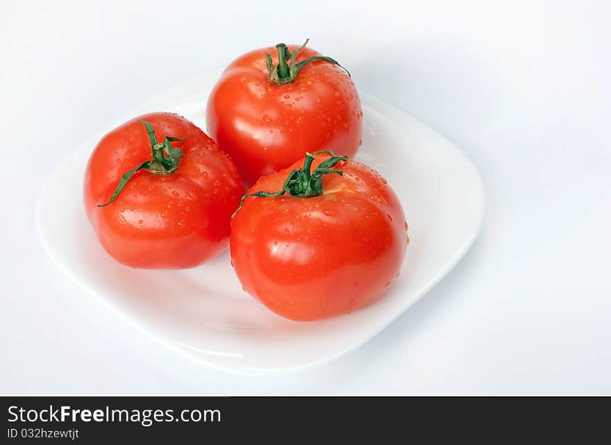 Juicy bright tomatoes on white plate. Juicy bright tomatoes on white plate