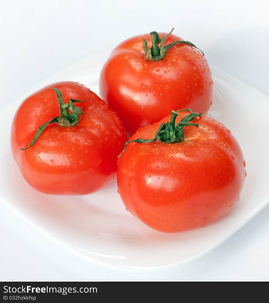 Juicy bright tomatoes on white plate. Juicy bright tomatoes on white plate