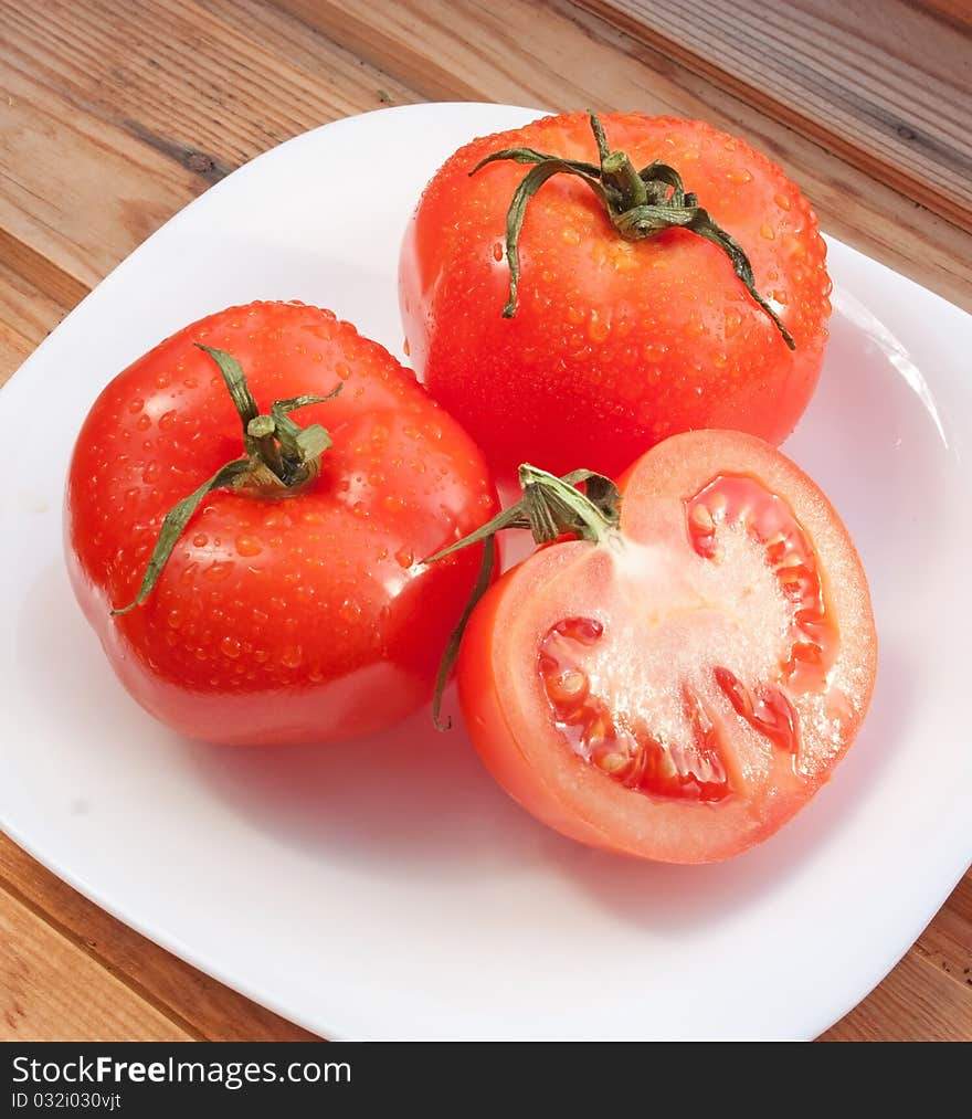 Juicy bright tomatoes on white plate. Juicy bright tomatoes on white plate