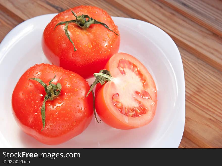 Juicy bright tomatoes on white plate. Juicy bright tomatoes on white plate