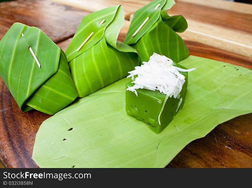 Tradition thai dessert, Green sweet pudding call Kanom Peakpoon made of Pandanus leaf flavor and coconut and banana leaf as it's packages