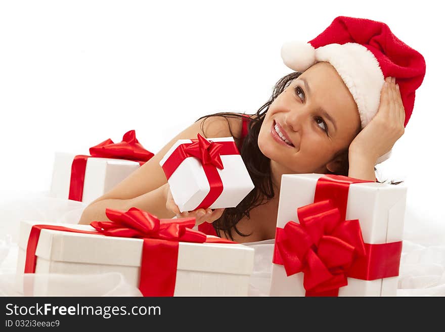 Beautiful sexy girl wearing santa hat with many gift boxes over white. Beautiful sexy girl wearing santa hat with many gift boxes over white