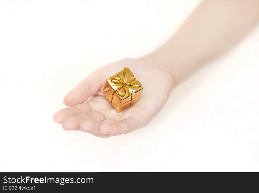 Woman's hand with a small yellow gift. Woman's hand with a small yellow gift