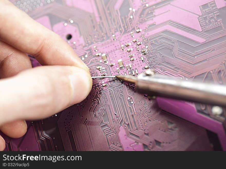 A close up shot of the backside of a computer circuit board, also known as a motherboard