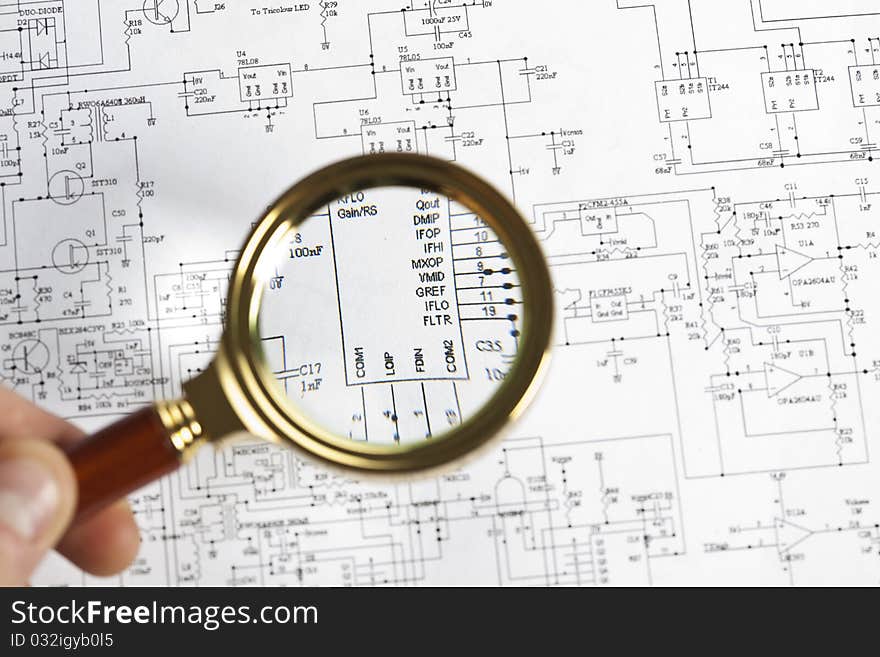 The approximation using a magnifying glass on the electronic schematic diagram.Ideal technology background.