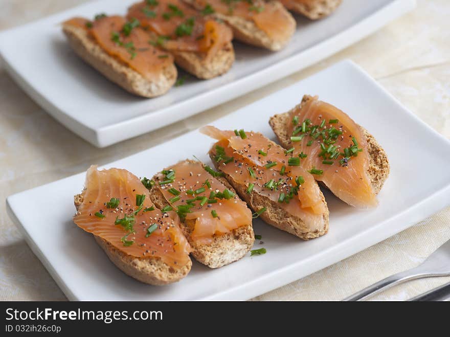 Swedish crisp bread topped with smoked salmon and chives. Swedish crisp bread topped with smoked salmon and chives