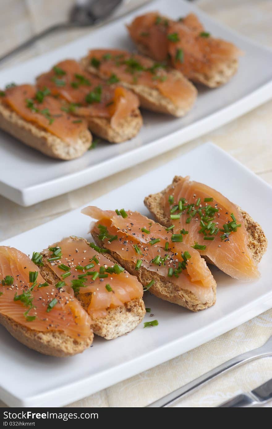 Swedish crisp bread topped with smoked salmon and chives. Swedish crisp bread topped with smoked salmon and chives