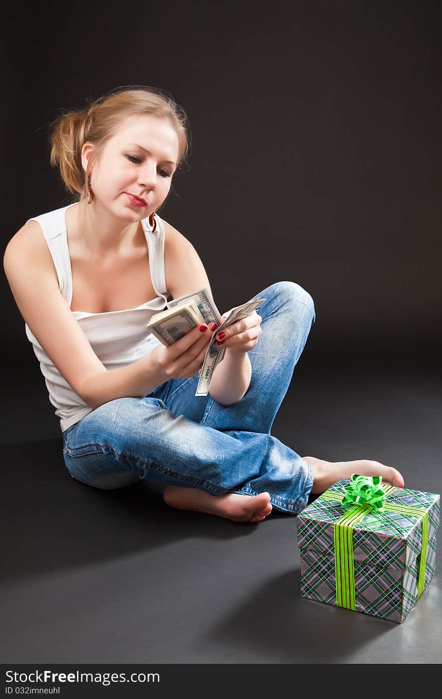 Beautiful girl with a gift against a dark background. Beautiful girl with a gift against a dark background