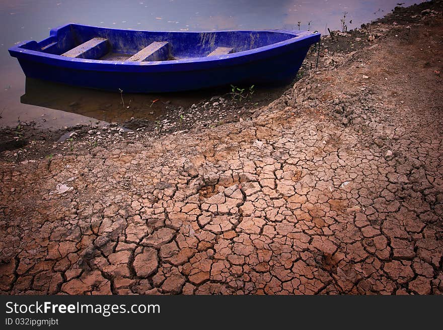 Plastic boat on dry soil