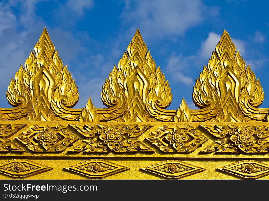 Golden cement sculpture of Thai art on the top of the temple's wall in Thailand. Golden cement sculpture of Thai art on the top of the temple's wall in Thailand